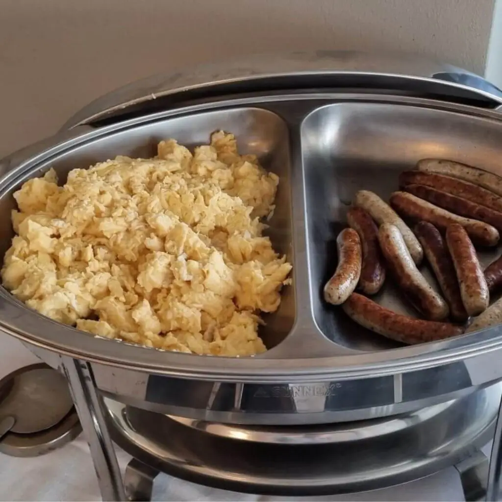 Frühstücksbuffet: Rührei und gebratene Würstchen in Edelstahl-Buffetbehälter