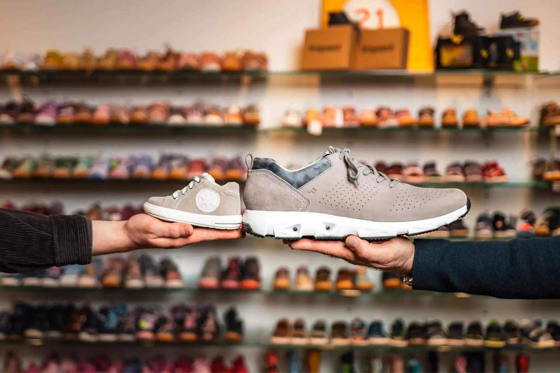 Ein kleiner Kinderschuh und ein großer Schuh, präsentiert im Schuhhaus Zentgraf